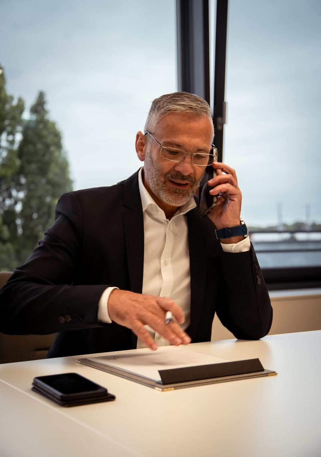 Geschäftsführer telefoniert am Besprechungstisch